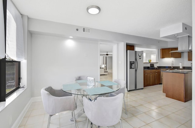 tiled dining room with a textured ceiling and sink