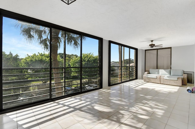 unfurnished sunroom featuring ceiling fan