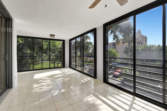 unfurnished sunroom with ceiling fan and a wealth of natural light