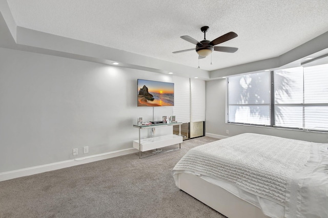 carpeted bedroom with ceiling fan and a textured ceiling