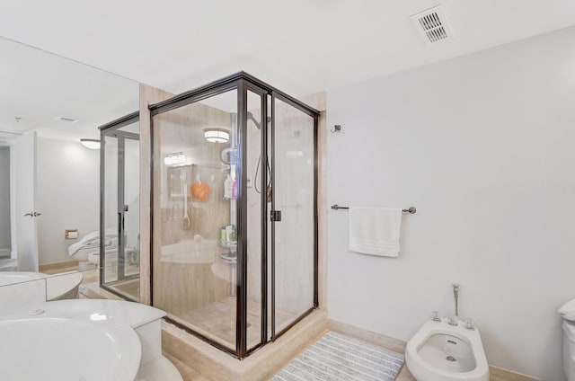 bathroom with toilet, walk in shower, and a bidet