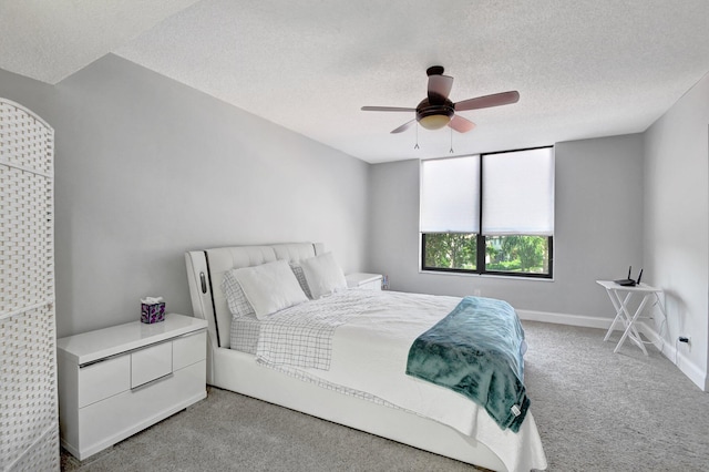 carpeted bedroom with ceiling fan and a textured ceiling