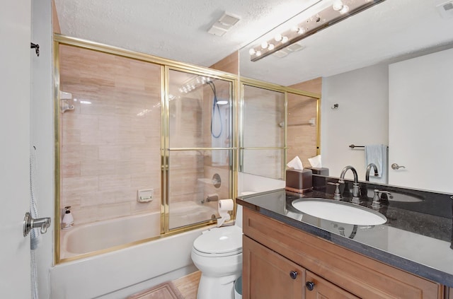 full bathroom with combined bath / shower with glass door, vanity, a textured ceiling, and toilet