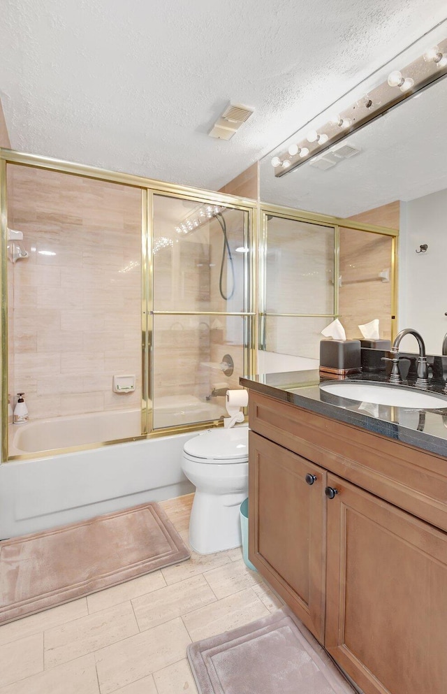 full bathroom featuring vanity, toilet, shower / bath combination with glass door, and a textured ceiling