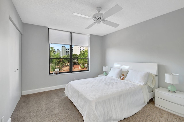 bedroom featuring carpet, ceiling fan, a textured ceiling, and a closet