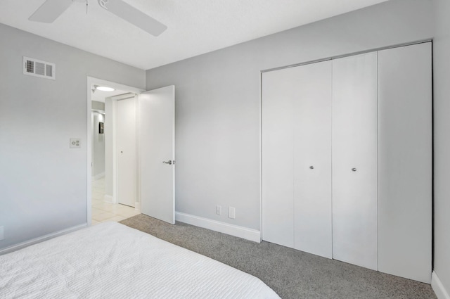 bedroom featuring a closet, ceiling fan, and light colored carpet