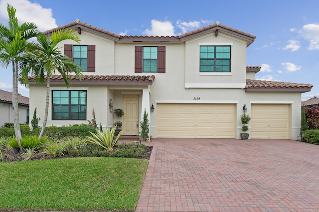 mediterranean / spanish house with a garage and a front yard