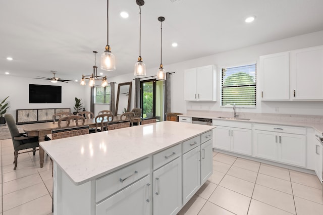 kitchen with white cabinetry, a kitchen island, plenty of natural light, and sink