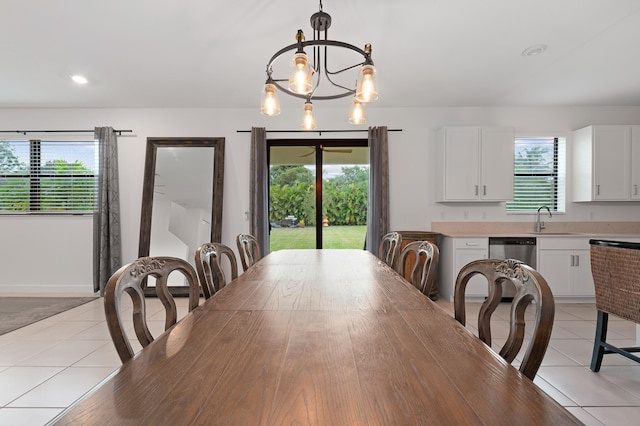 dining room with sink, plenty of natural light, light tile patterned floors, and an inviting chandelier