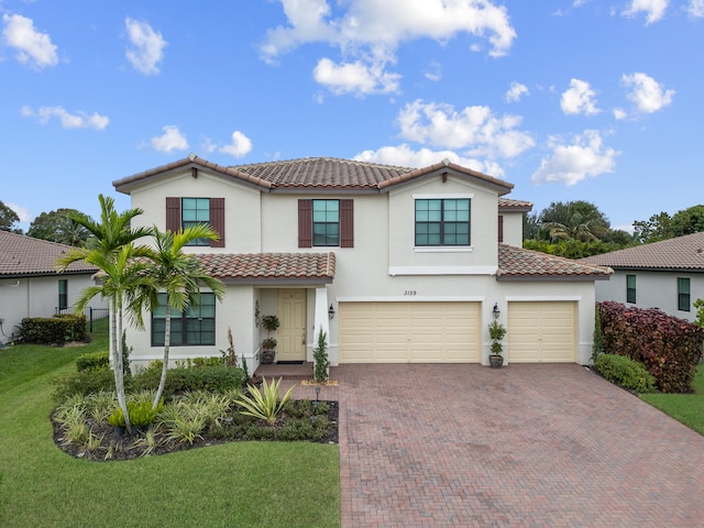 mediterranean / spanish-style home featuring a garage and a front yard