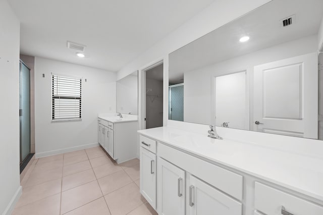 bathroom featuring vanity, tile patterned floors, and walk in shower