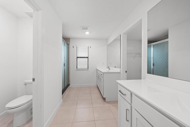 bathroom featuring tile patterned flooring, toilet, an enclosed shower, and vanity