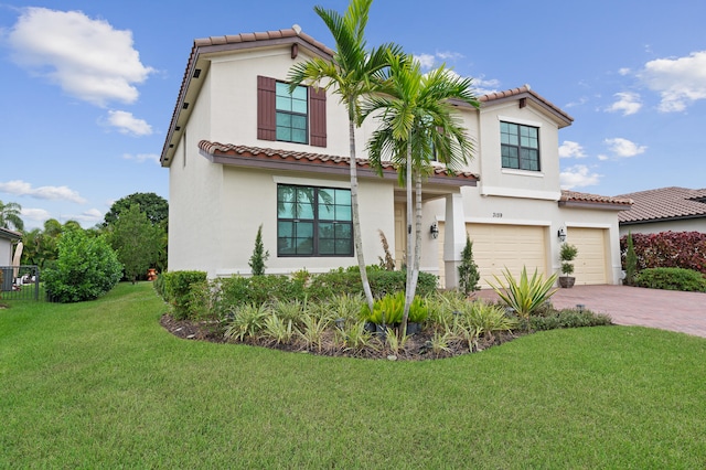 mediterranean / spanish-style home featuring a garage and a front lawn