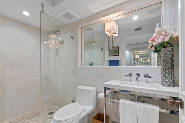 full bathroom with tile walls, tasteful backsplash, visible vents, toilet, and walk in shower