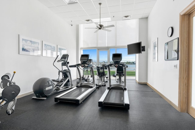 workout area featuring visible vents, a paneled ceiling, and baseboards