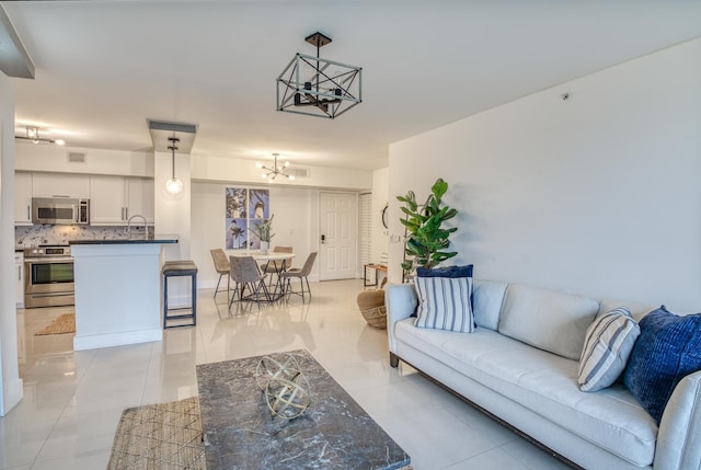 living room with light tile patterned flooring and a chandelier