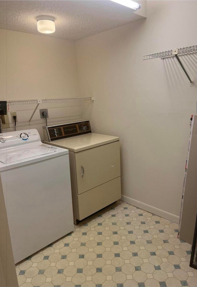 laundry area with washer and dryer and a textured ceiling