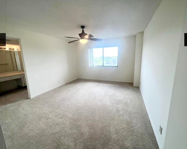 spare room featuring carpet, a textured ceiling, and ceiling fan