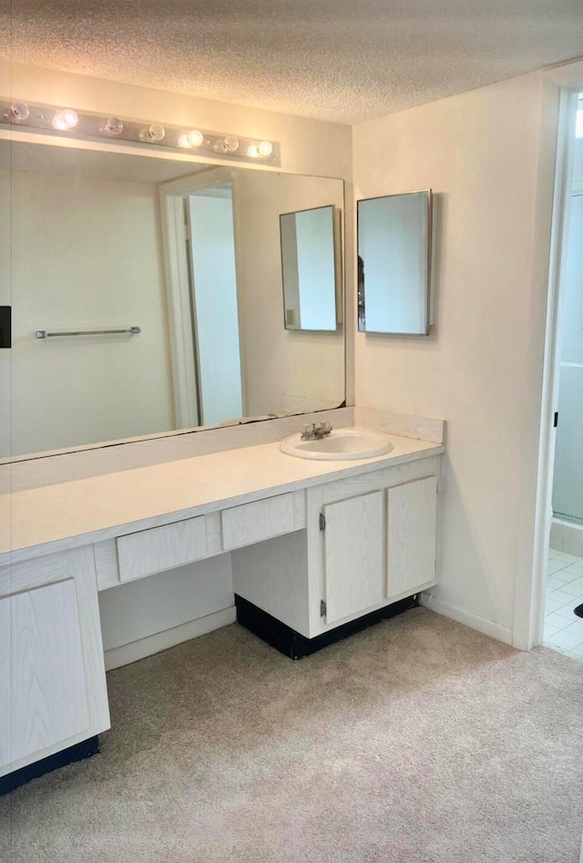 bathroom featuring a shower, vanity, and a textured ceiling