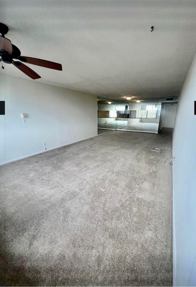 unfurnished living room featuring carpet flooring and a textured ceiling