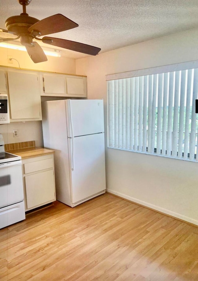 kitchen featuring a textured ceiling, ceiling fan, light hardwood / wood-style flooring, and white appliances