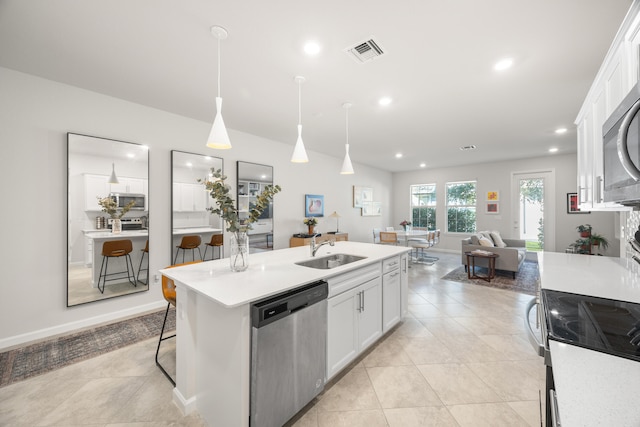 kitchen featuring pendant lighting, a breakfast bar, white cabinets, sink, and appliances with stainless steel finishes