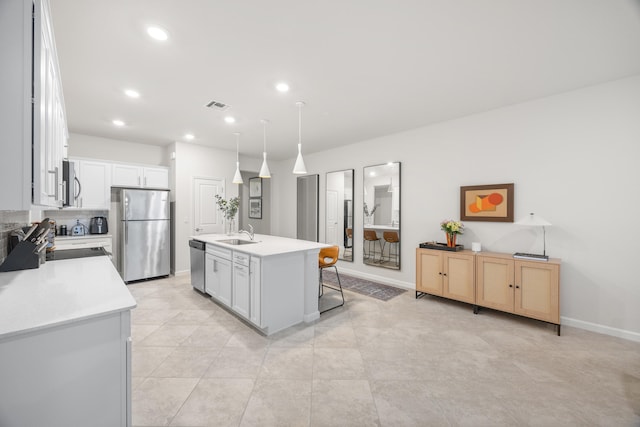 kitchen with a center island with sink, white cabinetry, sink, and appliances with stainless steel finishes