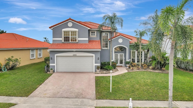 mediterranean / spanish home featuring a front lawn, a garage, and french doors