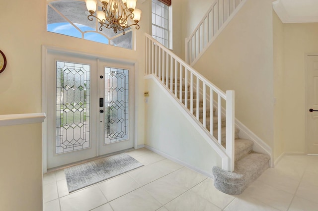 tiled entryway with a high ceiling and a notable chandelier