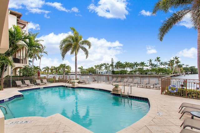 view of swimming pool with a patio area and a water view