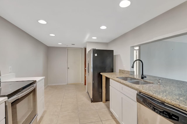 kitchen featuring sink, white cabinets, stainless steel appliances, and light tile patterned floors