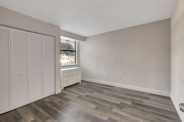 unfurnished bedroom with a closet, hardwood / wood-style floors, and a textured ceiling