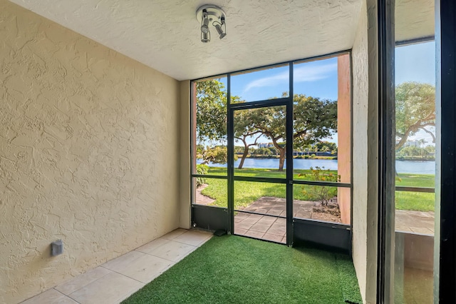 unfurnished sunroom featuring a water view