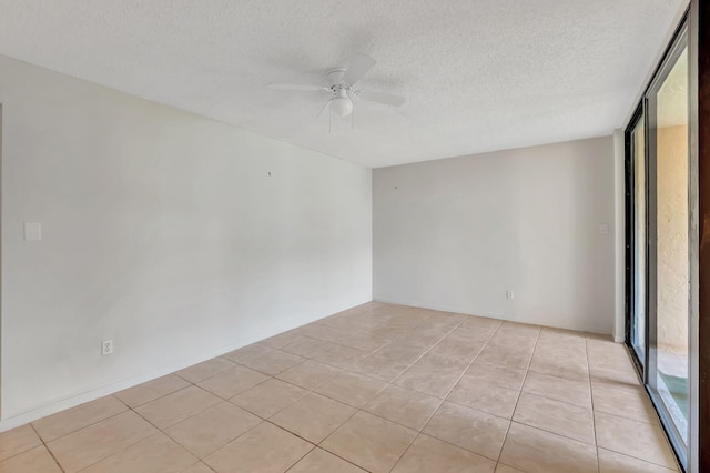 tiled spare room with a textured ceiling and ceiling fan