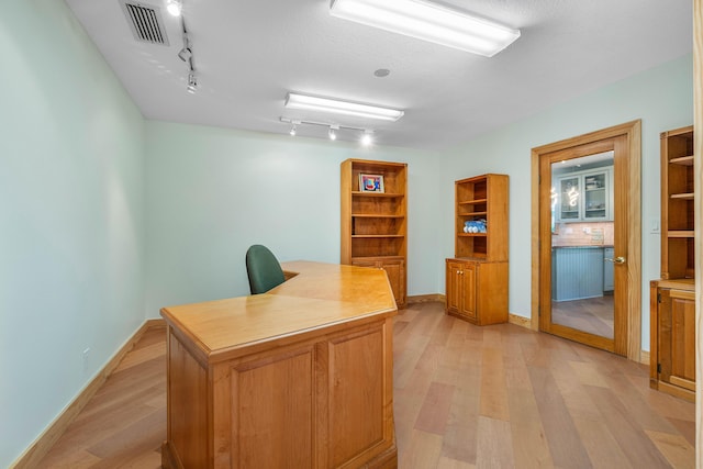 unfurnished office featuring baseboards, visible vents, and light wood finished floors