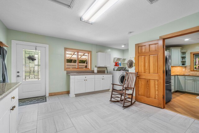 kitchen featuring open shelves, tasteful backsplash, washer / clothes dryer, freestanding refrigerator, and white cabinets