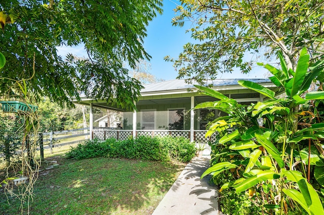 view of yard with fence and a sunroom