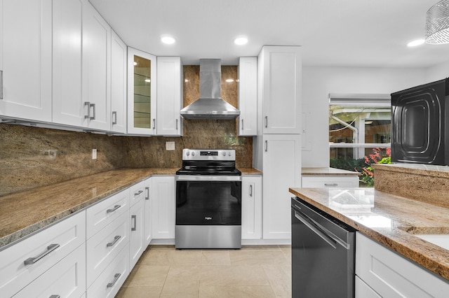 kitchen featuring stainless steel electric stove, black dishwasher, white cabinets, backsplash, and wall chimney range hood