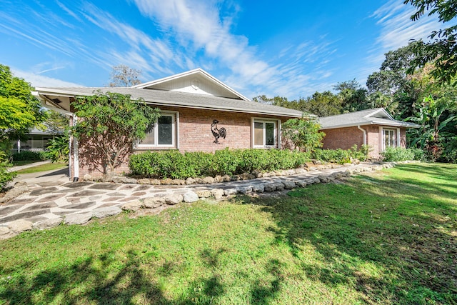 ranch-style home featuring a front yard and brick siding