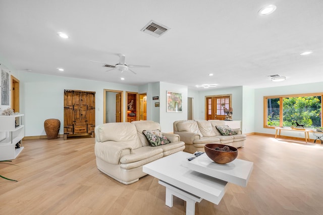 living room featuring light wood-style floors, baseboards, visible vents, and recessed lighting