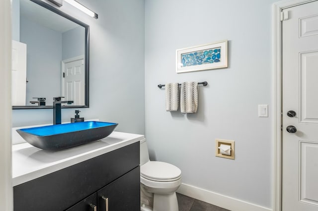 bathroom with tile patterned flooring, vanity, and toilet