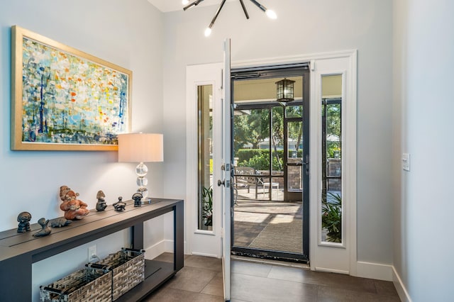 entrance foyer featuring light tile patterned flooring and an inviting chandelier