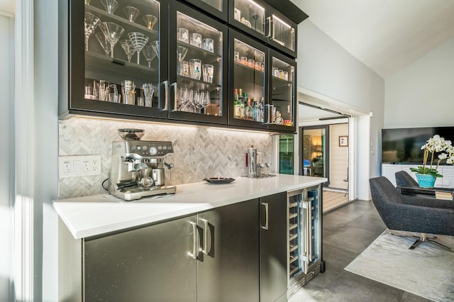 bar with decorative backsplash, beverage cooler, and lofted ceiling