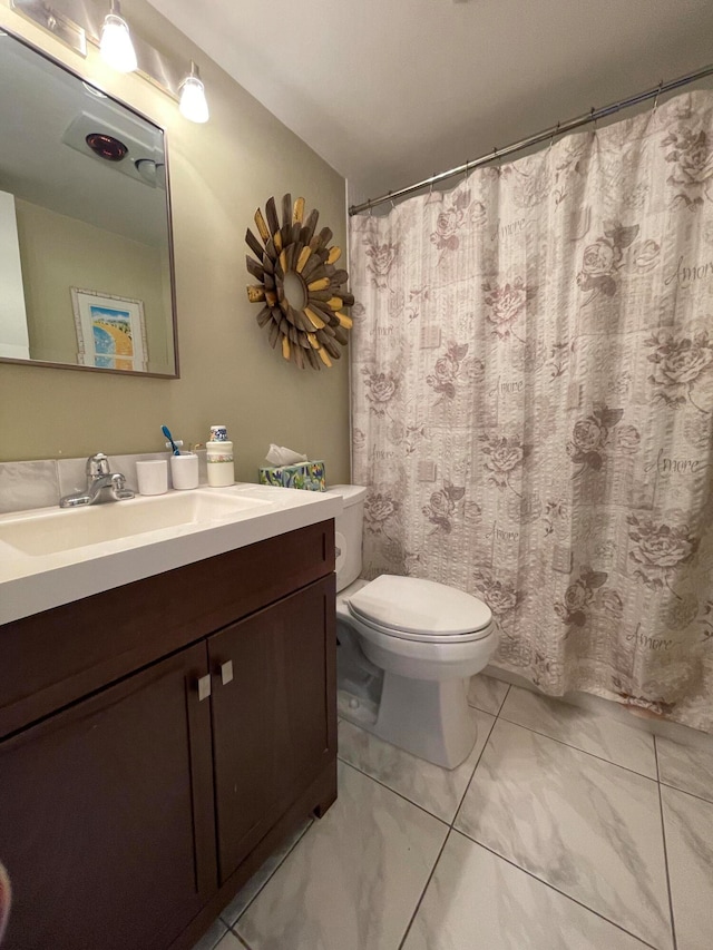 bathroom featuring tile patterned floors, vanity, and toilet