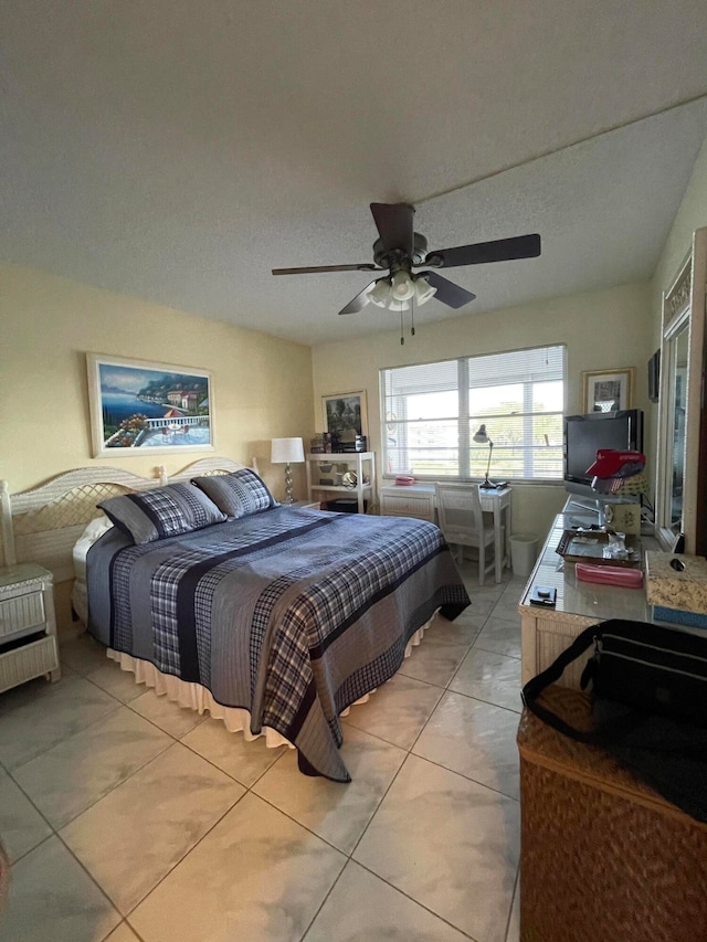 tiled bedroom with a textured ceiling and ceiling fan