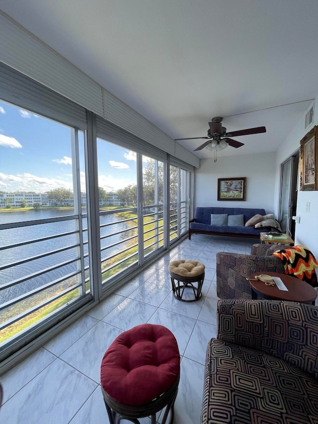 sunroom / solarium with ceiling fan and a water view