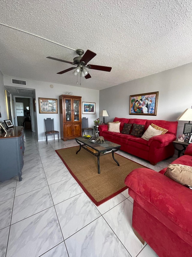 living room with ceiling fan and a textured ceiling