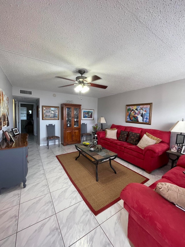 living room with ceiling fan and a textured ceiling