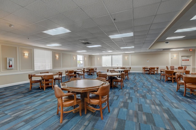 carpeted dining room featuring a drop ceiling