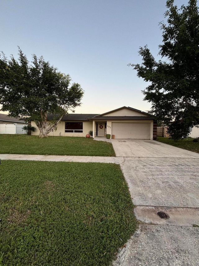 ranch-style house with a yard and a garage